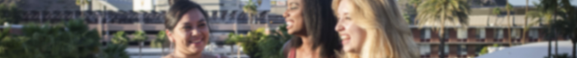 Three smiling women on top of University Bridge